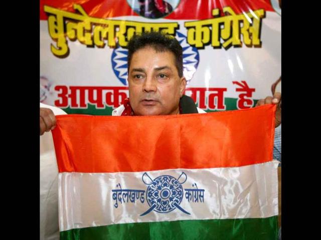 Bundelkhand Mukti Morcha chief Raja Bundela shows the flag of his newly launched party Bundelkhand Congress at a press conference in Lucknow.