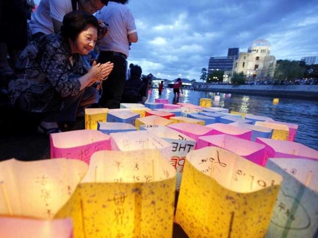 A woman prays after releasing a paper lantern on a river facing the gutted Atomic Bomb Dome in remembrance of atomic bomb victims on the 66th anniversary of the bombing in Hiroshima. Prime Minister Naoto Kan took his campaign against nuclear energy in Japan to Hiroshima which 66 years ago became the world's first victim of an atomic bomb.