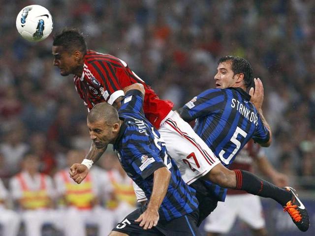 AC Milan's Kevin-Prince Boateng (top) dives for a header as he is challenged by Inter Milan's Walter Adrian Samuel (bottom) and Dejan Stankovic during their Italian Super Cup soccer match at the National Olympic Stadium in Beijing.