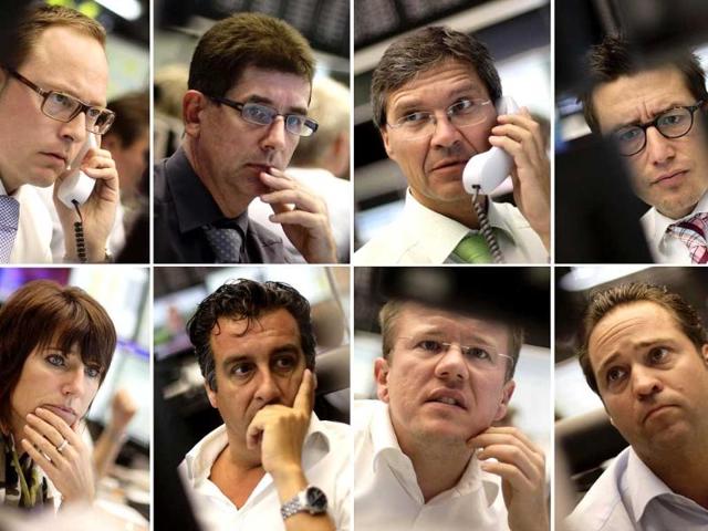 A combination of eight pictures show share traders reacting in front of their monitors at Frankfurt's stock exchange.