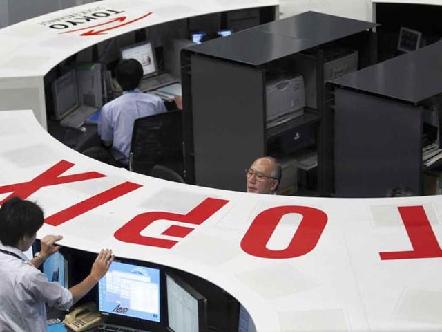 Staff members of the Tokyo Stock Exchange monitor the stock market.