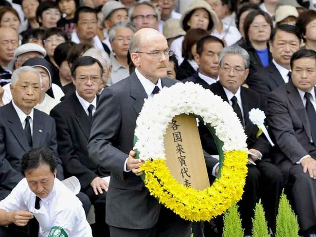 James Zumwalt, deputy chief of mission at the US Embassy in Tokyo, carries a wreath to the altar set up in Nagasaki Peace Park in Nagasaki, southern Japan.