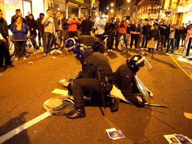 Police-arrest-a-man-for-looting-in-Clapham-Junction-in-south-London-Violence-and-looting-spread-across-some-of-London-s-most-impoverished-neighborhoods-with-youths-setting-fire-to-shops-and-vehicles-during-a-third-day-of-rioting-in-the-city-that-will-host-next-summer-s-Olympic-Games Police-arrest-a-man-for-looting-in-Clapham-Junction-in-south-London-Violence-and-looting-spread-across-some-of-London-s-most-impoverished-neighborhoods-with-youths-setting-fire-to-shops-and-vehicles-during-a-third-day-of-rioting-in-the-city-that-will-host-next-summer-s-Olympic-Games