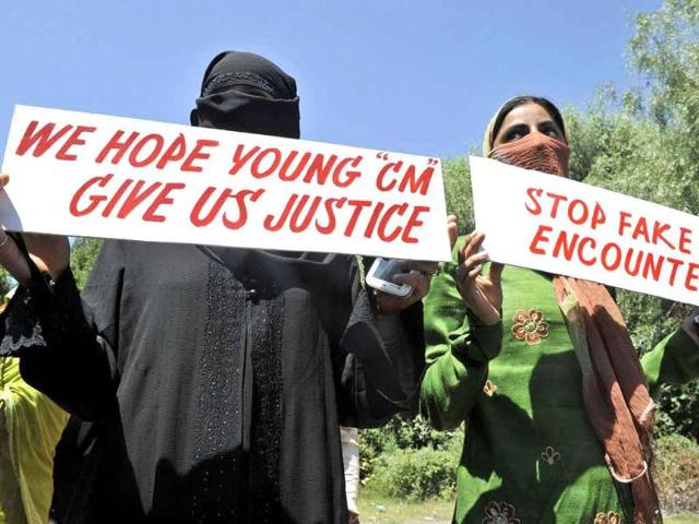 Kashmiri women hold up placards as they protest against fake encounters and custodial killings in Srinagar.