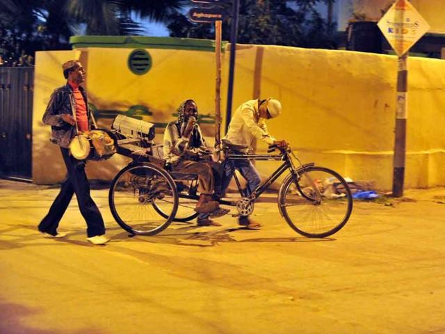Visually impaired singer Mohammed Sheik Khaja Bhai (C) is pulled on a tricycle by his son Ahmed Bhai (R) and drummer Mohammed Haji Bhai (L) as they roam the streets of the old city in Hyderabad in the early hours during the holy fasting month of Ramadan.