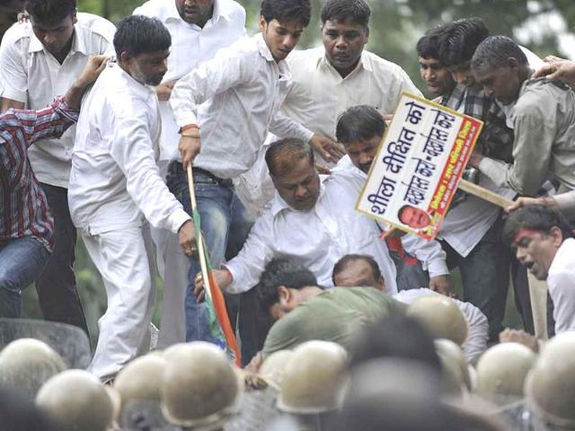 BJP activists stand on top of police barricades during a protest against the Congress-led UPA government in New Delhi. Hundreds of BJP activists marched to the Parliament against the ruling government's alleged inaction in handling corruption.