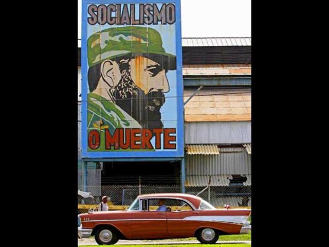 A car drives past a billboard showing Cuban leader Fidel Castro with the words reading in Spanish 'Socialism or death', in Havana, Cuba.