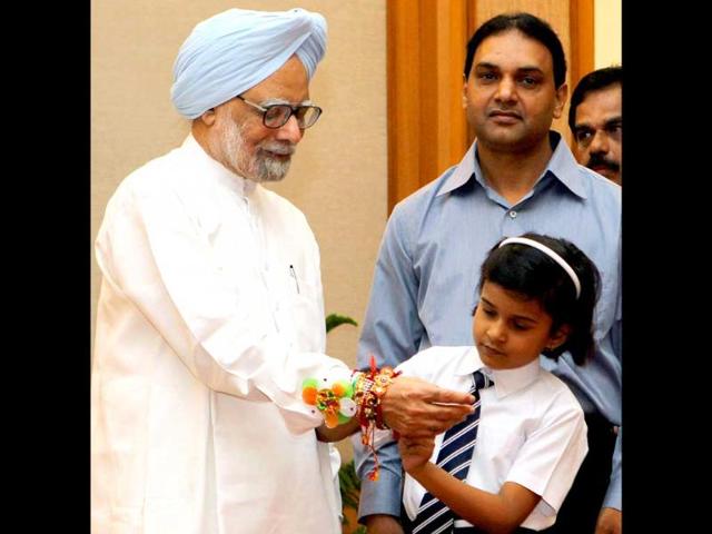 A school-girl tying rakhi to Prime Minister Manmohan Singh on Raksha Bandhan celebration at his residence in New Delhi.