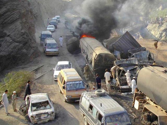 Vehicles drive past as residents gather near burning oil tankers, used to carry fuel for NATO forces in Afghanistan, after they were hit by a bomb attack in the outskirts of Landikotal, northwest Pakistan. A bomb blast destroyed four trucks carrying fuel for US-led NATO forces in Afghanistan in Pakistan's northwestern tribal region of Khyber late on Monday, local government officials said.