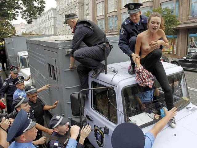 Policemen detain an activist from the women's rights organization "Femen" on the roof of a police wagon for transportation of detainees during a protest rally near the Pecherskiy District Court in Kiev. Women aimed at directing the public attention to the fact that, in their opinion, there were many criminals in the country who could be brought to justice and be transported in police wagons, while Ukrainian authorities concentrated on former Prime Minister Yulia Tymoshenko only, according to organizers.