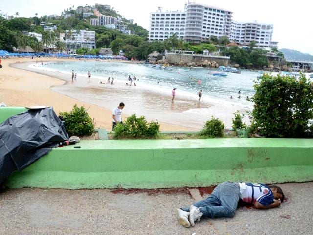 The bodies of two men shot dead next to the Caleta beach in the Pacific resort city of Acapulco, Mexico. Acapulco has been hit by violence as drug gangs continue to battle for control of the region.