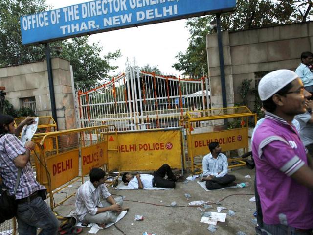Tired supporters of anti-corruption activist Anna Hazare rest after a night-long vigil outside a gate of Tihar jail to lend their support to his fight against corruption in New Delhi.