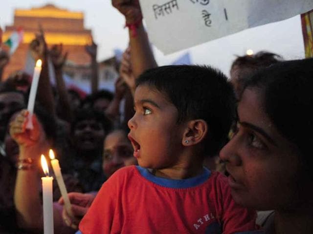 Anna Hazare supporters shout anti-government slogans and hold lighted candles during a rally in his support at India Gate in New Delhi.