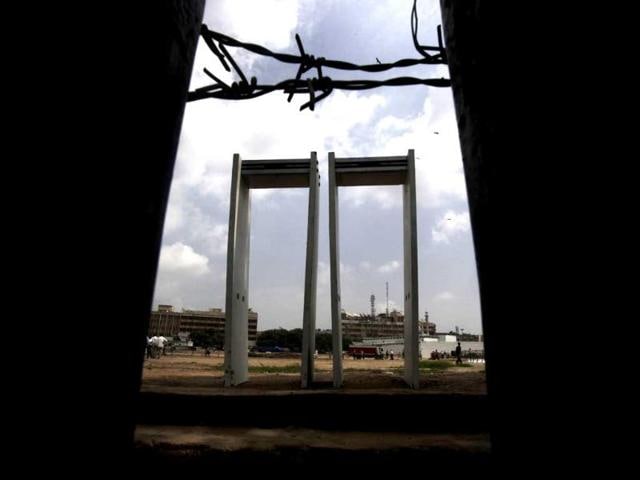 Metal detectors stand at the entrance as laborers prepare the venue for a public protest by anti-corruption activist Anna Hazare.