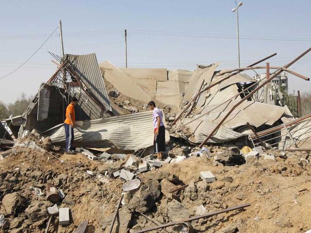 Palestinians inspect the site of an overnight Israeli air raid in Khan Yunis in the southern Gaza Strip.