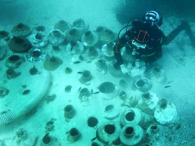 A diver pushes Roman ancient amphoras down onto sand off the coast of the Frioul island, southern France. Discovered in 1952 by French undersea explorer Commander Jacques-Yves Cousteau and the Calypso team during the excavations of the "Grand-Congloué" shipwreck, 250 amphoras were submerged for four days this week, in the Frioul island site dedicated to diving exploration.