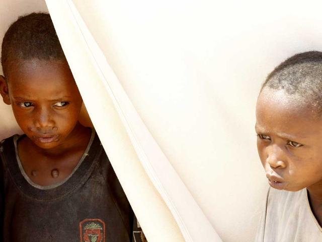 Children sit at the entrance of their tent in a settlement for internally displaced people in Mogadishu.