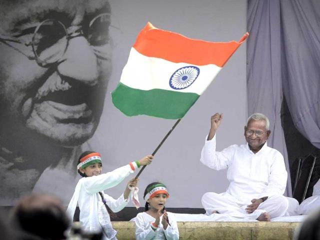 A girl waves national flag and another sings a patriotic song beside India's anti-corruption crusader Anna Hazare during his hunger strike in New Delhi.