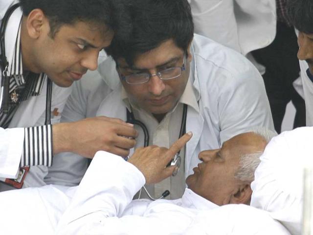 Social activist Anna Hazare speaks to doctors as they examine him on the sixth day of his fast at Ramlila grounds in New Delhi.