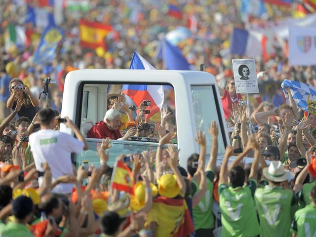 Pope Benedict XVI waves to faithful from his popemobile as he arrives to celebrate a mass on a vast dusty esplanade outside Madrid during the World Youth Day (WYD) festivities.
