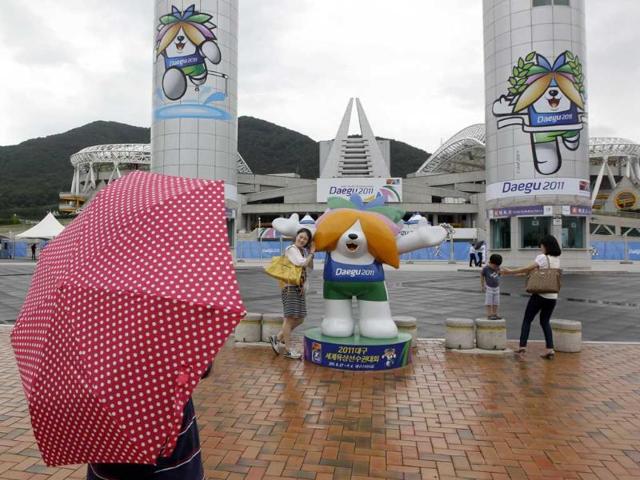 A woman poses close with the mascot of World Athletics Championships outside the stadium in Daegu, South Korea.