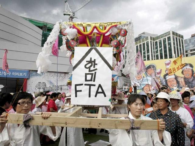 South Korean female farmers carry a traditional coffin representing the death of the free trade agreement.