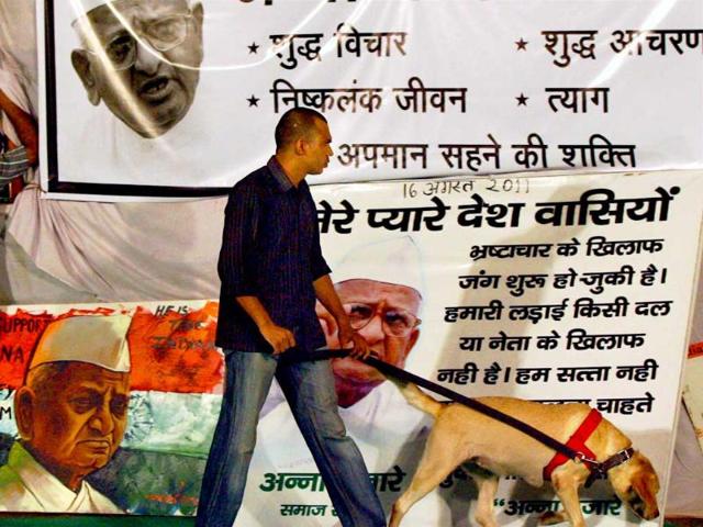 A security person inspects with a sniffer dog near Anna Hazare's stage at Ramlila Ground.