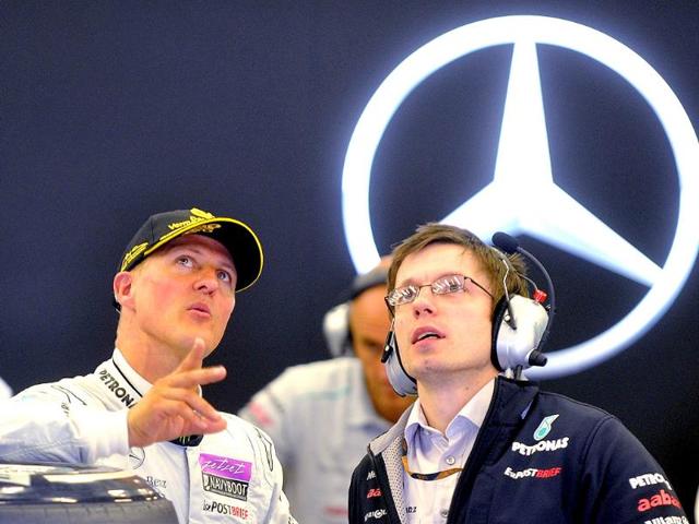 Mercedes Formula One driver Michael Schumacher (L) of Germany talks to a mechanic as they stand in the pit during a practice session of the Belgian F1 Grand Prix in Spa-Francorchamps.