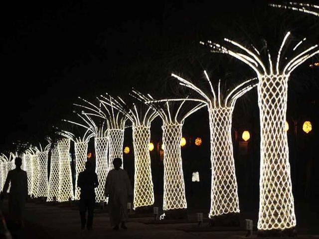 Saudis walk on King Abdullah Street decorated with lights ahead of celebrations for Eid al-Fitr which marks the end of the Muslim holy fasting month of Ramadan, in Riyadh.