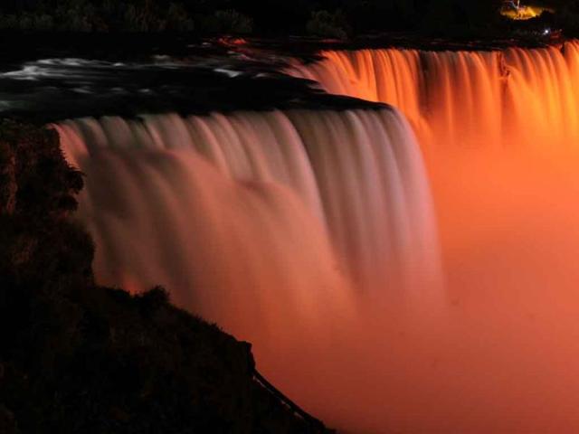 Niagara Falls is illuminated in orange, to honor the late New Democrats party leader Jack Layton in Niagara Falls, New York.