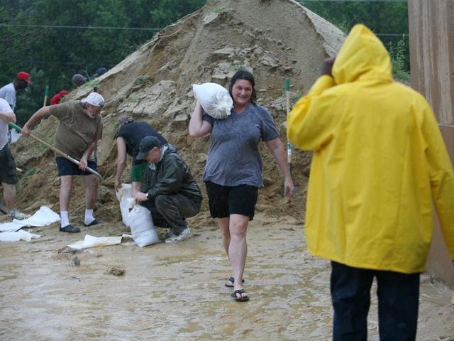 Priscilla Girasole, of Chesapeake Beach, Md., carries a sandbag away as other residents load sandbags at a government facility in Calvert County, Md., in preparation for Hurricane Irene.