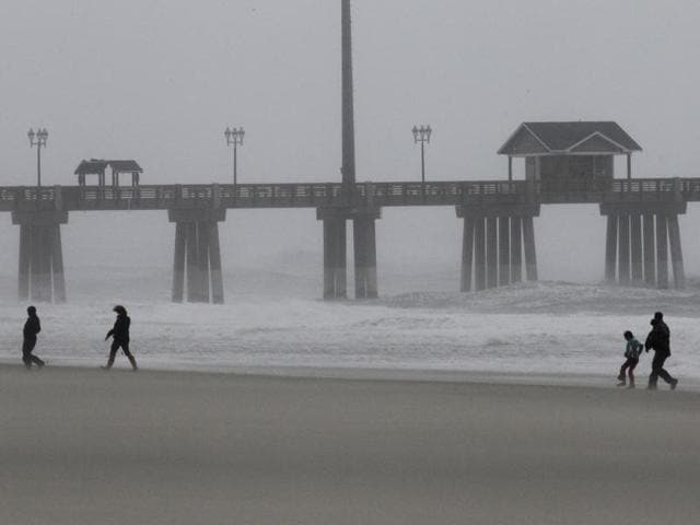 People venture onto the beach in the blowing sand and rain as the effects of Hurricane Irene are felt in Nags Head, NC.