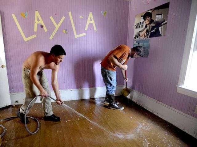 BJ Cahoon (L), 23, helps Ivan Ireland, 45, wash down Ivan's daughter's bedroom in hopes of salvaging the house the day after they survived Hurricane Irene on Goose Creek Island in Lowland, North Carolina.