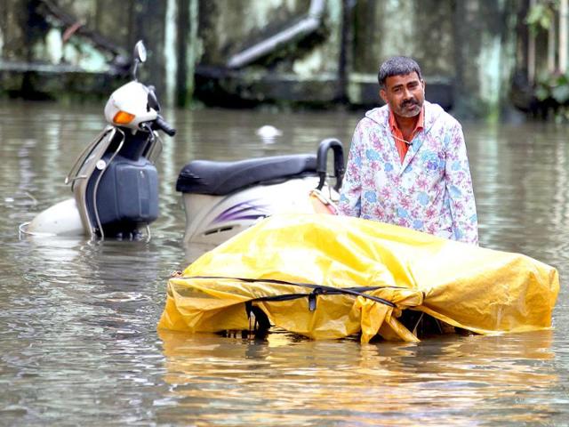 Vegetable vendor walks through flooded water in BPT colony at Wadala during heavy rain in Mumbai.