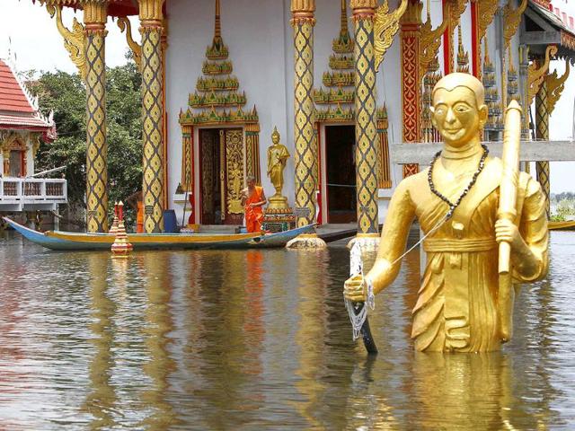 A monk stands outside the main hall of a flooded temple in Nakornsawan province, north of Bangkok.
