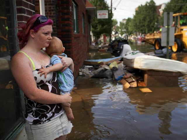 A woman and her baby look out over a flooded street in Wallington, New Jersey.
