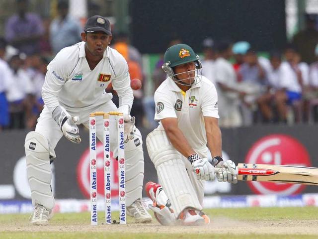 Australian batsman Usman Khawaja, right, reacts after attempting a reverse sweep in front of Sri Lankan wicket keeper Prasanna Jayawardene during the third day of their first Test cricket match in Galle, Sri Lanka.