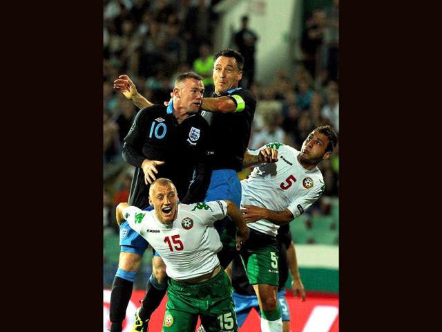 England forward Wayne Rooney (top L) scores a goal against Bulgarian during the Euro 2012 qualifying football match at the Vassil Levski stadium in Sofia.