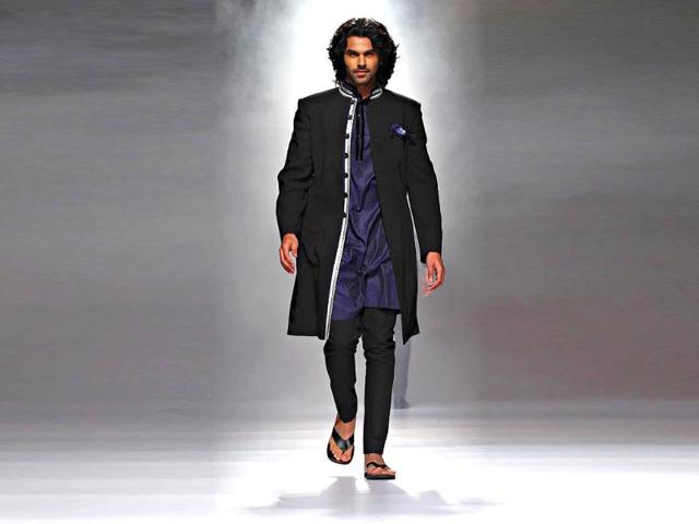 A model looks dapper in a collared kurta and with churidaar by Rajvi Mohan.