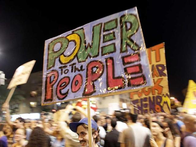A man holds a sign during a demonstration calling for lower living costs and social justice in Tel Aviv.