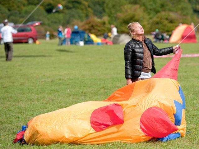 A woman enjoys the sun's heat as she holds the line of a kite at the 25th annual Bristol International Kite Festival on the Ashton Court Estate near Bristol.
