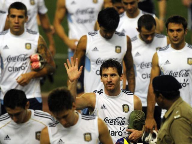 Argentine footballer Lionel Messi (C) gestures to supporters following a training session in Kolkata.