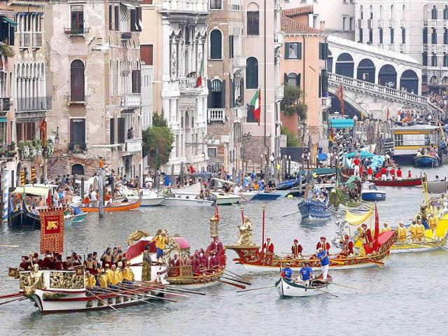 Venetians row down the Grand Canal, led by the famous Bucintoro boat (bottom L) in Venice.