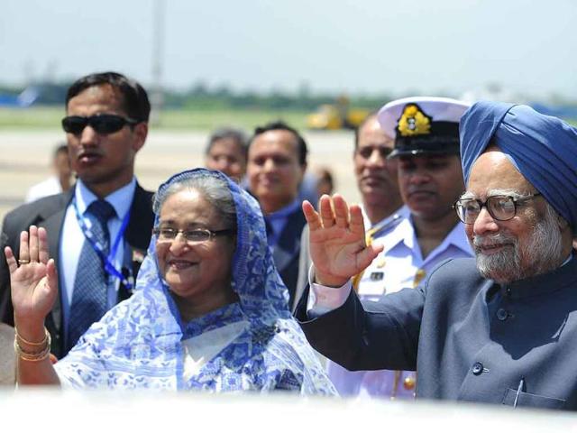 Prime Minister Manmohan Singh (R) and his Bangladeshi counterpart Sheikh Hasina Wajid wave at the Hazrat Shahjalal International Airport in Dhaka.