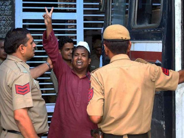 Suhail Hindustani, an accused in cash-for-votes scam, flashes the victory sign as he is taken to the Tihar jail after he was produced in Tis Hazari court in New Delhi.