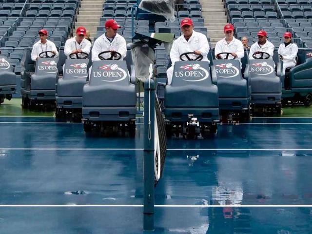 Workers dry the court in Arthur Ashe Stadium during Day Ten of the 2011 US Open at the USTA Billie Jean King National Tennis Cente in the Flushing neighborhood of the Queens borough of New York City.