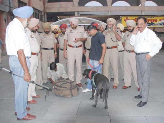 Police checking bags of passengers at the Amritsar bus stand following the Delhi high court blast.