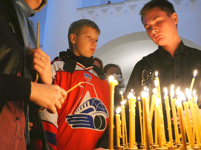 People wearing the club jerseys of Russian ice hockey team Lokomotiv Yaroslavl light candles during a commemorative service in a church in Yaroslavl. At least 44 people were killed when a Russian jet carrying hockey players of Lokomotiv Yaroslavl to their first match of the KHL (Kontinental Hockey League) season crashed on takeoff.
