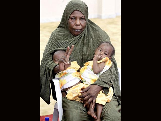 A Libyan woman carrying her two children gestures at the port in Tripoli, as she waits for the first passenger ship from Tripoli to go to Benghazi since the start of the uprising against Muammar Gaddafi's rule.
