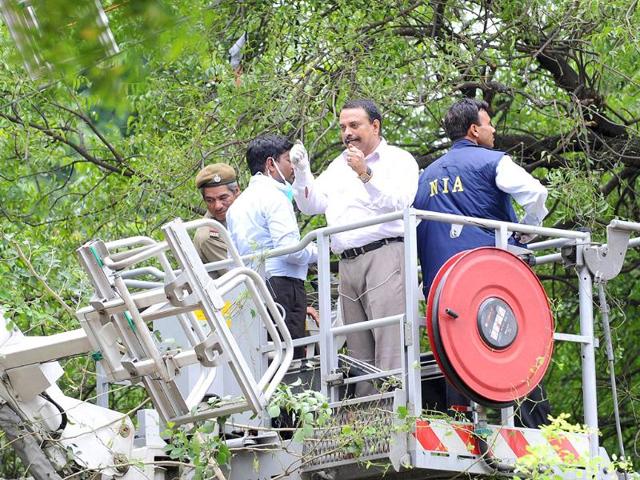 National Intelligence Agency officers inspect and collect evidence from a deadly bomb blast at the Delhi high court in New Delhi.